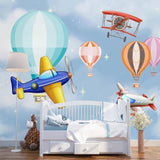 Hot air balloon wallpaper bringing color to playroom with reading nook and toy storage