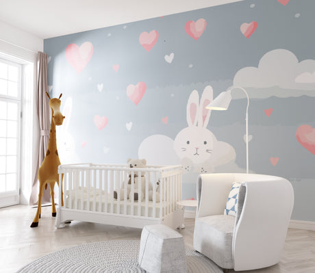 Bunny nursery wallpaper in a modern white nursery with gray rocking chair and pink accessories