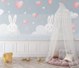 Kids room with pink and gray bunny wallpaper showcasing modern furniture and natural lighting