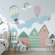 Hot air balloon nursery wallpaper in cozy bedroom with white furniture and soft lighting