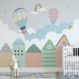 Rainbow and hot air balloon wall mural creating magic in playroom with reading nook
