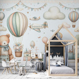 Hot air balloon nursery wallpaper in soft pastels shown in a bright children's bedroom with white furniture and natural light