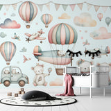 Hot air balloon nursery wallpaper with teddy bears shown in a bright kids bedroom with white furniture and natural light
