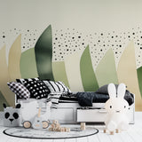 Children's bedroom with abstract sage green wallpaper creating a calm, modern atmosphere