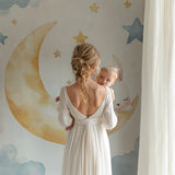 Moon and bunny wallpaper in a girl's bedroom with pink accents and reading nook