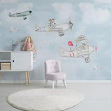 Kids bedroom with flying animals wall mural, showing playful aircraft and animal characters above a cozy reading nook