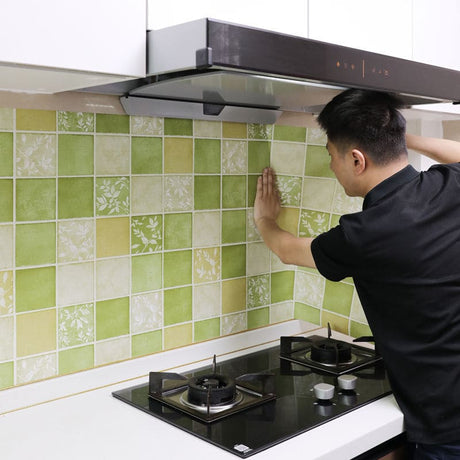 Green floral mosaic wallpaper brightening a modern kitchen with white cabinets and natural light