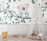 Nursery wall mural with koalas and eucalyptus leaves in a playroom setting