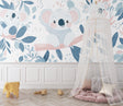 Koala nursery wallpaper creating a peaceful atmosphere in a modern white nursery with natural wood furniture