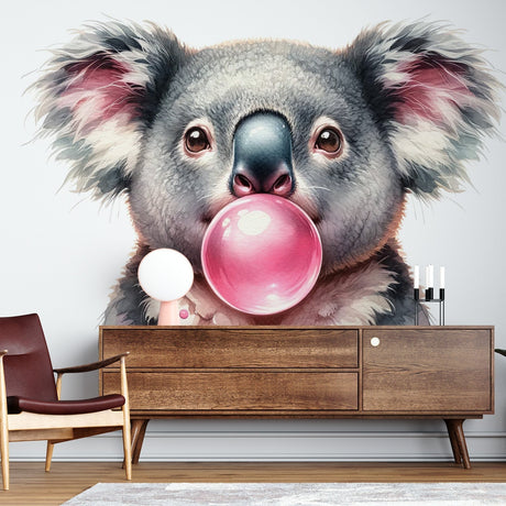 Koala wallpaper mural displayed in a bright modern nursery, showing a cute koala blowing pink bubble gum against a soft grey background