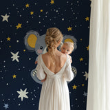 Starry koala wall mural creating a cozy reading nook in a toddler's bedroom