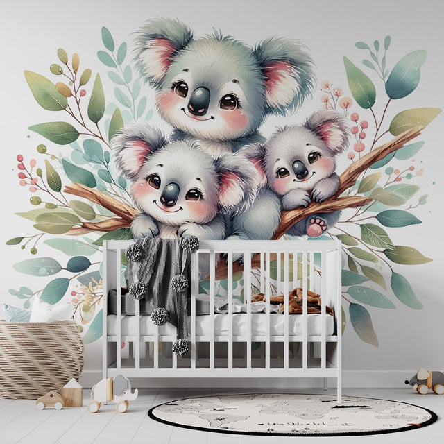 Koala family wallpaper mural in a bright nursery setting, showing three cute koalas among watercolor leaves