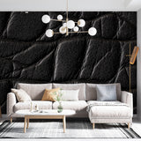 Black leather textured wallpaper creating dramatic effect in modern living room with contemporary furniture