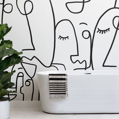 Line art face wallpaper creating a striking focal point in a minimal Scandinavian living room