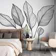Black and white botanical line art wallpaper creating a modern accent wall in a bright, minimalist living room setting
