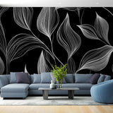 Black and white botanical line art wallpaper showcased in a modern living room with minimal furniture