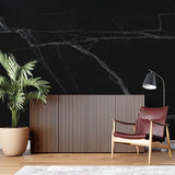 Elegant dining room featuring black marble wall mural with striking white veining pattern