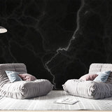Black marble wallpaper with white veins creating a dramatic effect in a modern living room with high ceilings