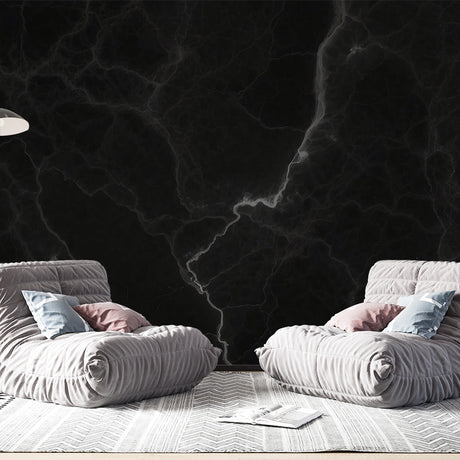 Black marble wallpaper with white veins creating a dramatic effect in a modern living room with high ceilings