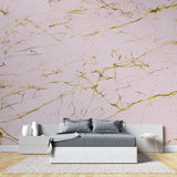 Master bedroom with pink and gold marble accent wall creating a luxurious atmosphere
