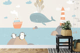 Marine animals wallpaper in a bright kids bedroom, showing playful whale and penguins design above a cozy reading nook
