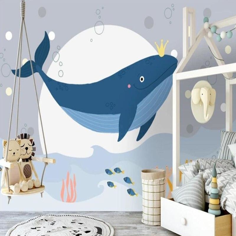 Whale wall mural displayed in modern nursery setting, showing the calming blue tones and golden crown details