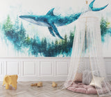 Watercolor whale mural adding depth to a nursery with gentle blue and green tones