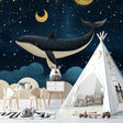 Marine whale wallpaper creating magical atmosphere in modern nursery with soft lighting