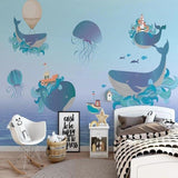 Marine life wallpaper creating a magical atmosphere in a modern nursery with floating whales and jellyfish