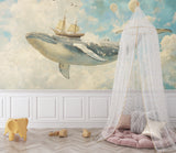 Nautical wallpaper adding whimsy to a playroom with floating whale and ship design