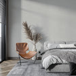 Modern grey wallpaper in a bright living room setting with minimal furniture and natural light