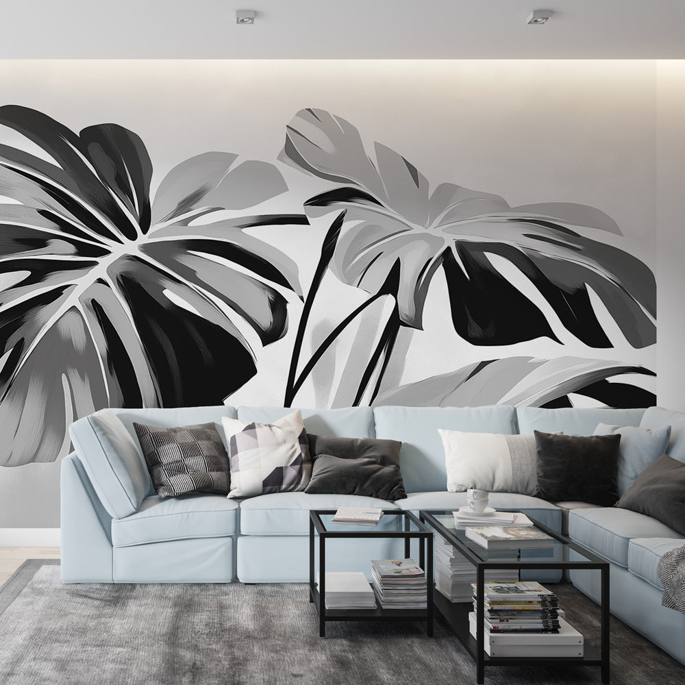 Black and white Monstera wallpaper creating drama in a modern living room with minimal furniture