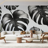 Modern dining room with Black and White Monstera Leaf Wallpaper creating dramatic contrast against minimalist furniture