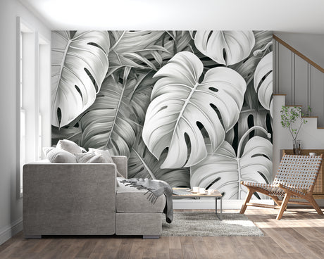Black and white Monstera leaf wallpaper creating drama in modern living room with minimal furniture