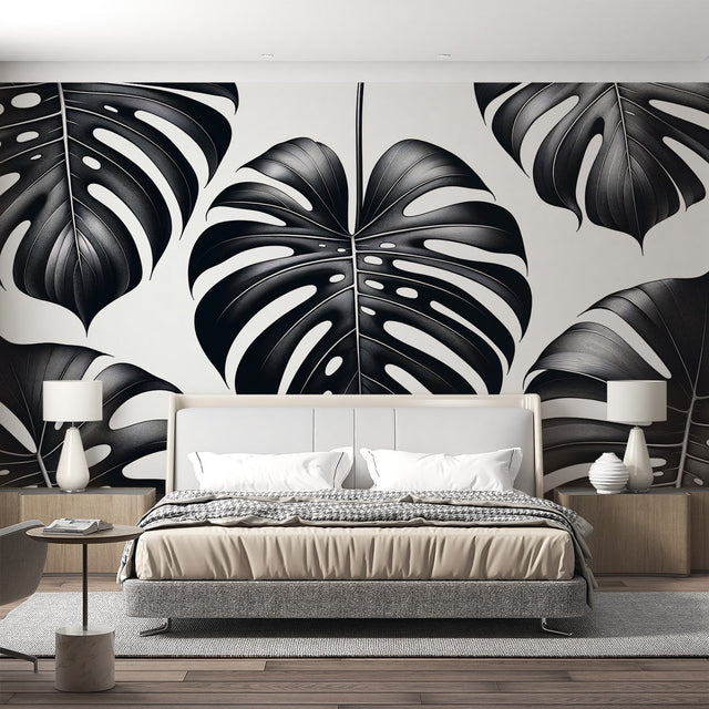 Modern black and white Monstera leaf wallpaper creating a striking focal point in a minimalist living room setting
