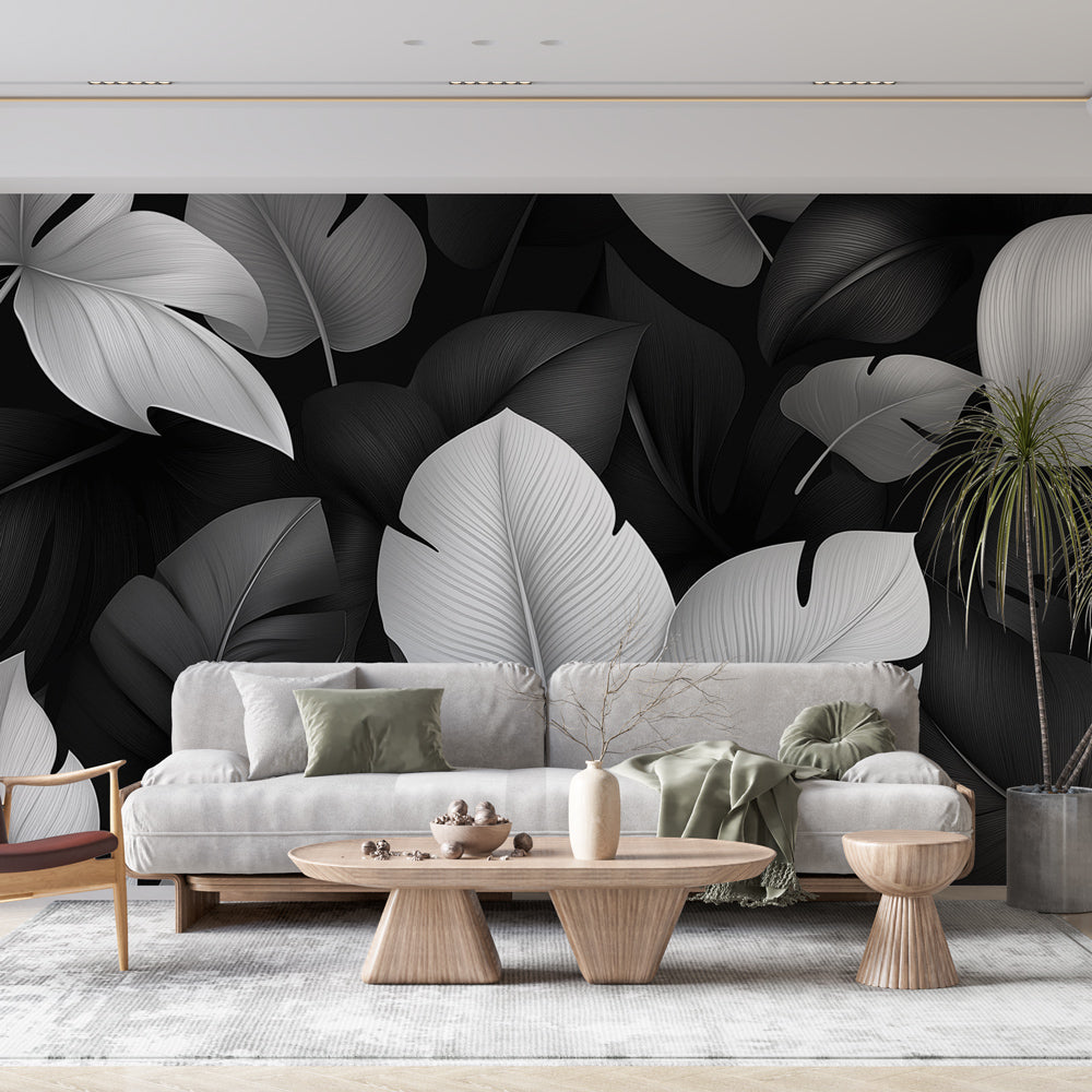 Modern living room with black and white Monstera leaf wallpaper creating a bold statement wall behind grey sofa