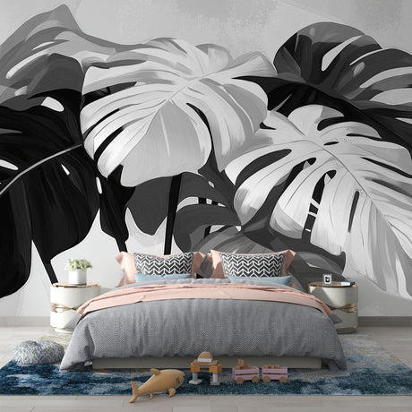 Black and white Monstera leaf wallpaper creating a striking focal point in a modern living room with minimalist furniture