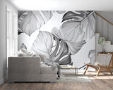 Black and white Monstera wall mural creating a focal point in a minimalist bedroom