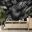 Black and white Monstera leaf wallpaper creating drama in a modern living room with minimalist furniture