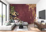 Tropical wall mural bringing warmth to hallway with golden monstera leaves on deep burgundy