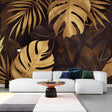 Monstera leaf wallpaper in gold and black creates drama in modern living room with pendant lights