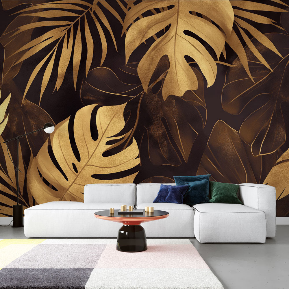 Monstera leaf wallpaper in gold and black creates drama in modern living room with pendant lights
