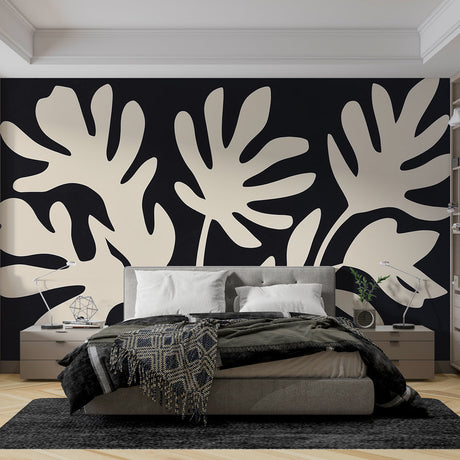 Modern black and white Monstera leaf wallpaper in a bright living room with minimal furniture and natural light