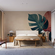 Modern Monstera leaf wallpaper creating a bold statement wall in a bright dining room with minimal furniture