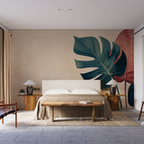 Modern Monstera leaf wallpaper creating a bold statement wall in a bright dining room with minimal furniture