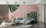 Modern living room with pink and green Monstera leaf wallpaper creating a fresh tropical atmosphere