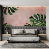 Home office with pink Monstera leaf mural adding natural charm