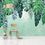Monstera leaf wallpaper creating a fresh vibe in a modern living room with white furniture