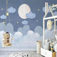 Moon and stars wallpaper in a cozy nursery with soft lighting showing the dreamy night sky design