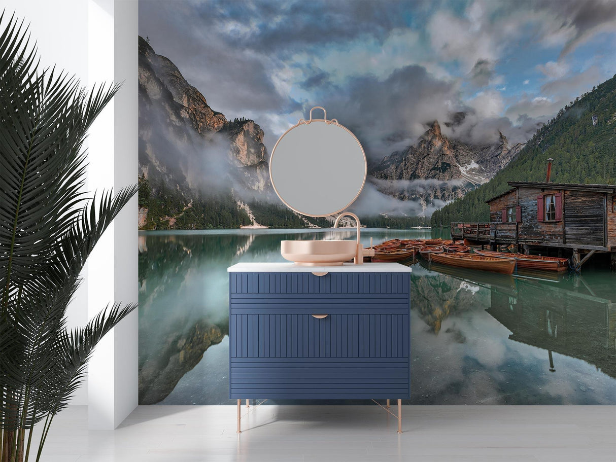 Mountain lake wallpaper creating depth in a modern living room, reflecting natural light with misty peaks and boathouse scene